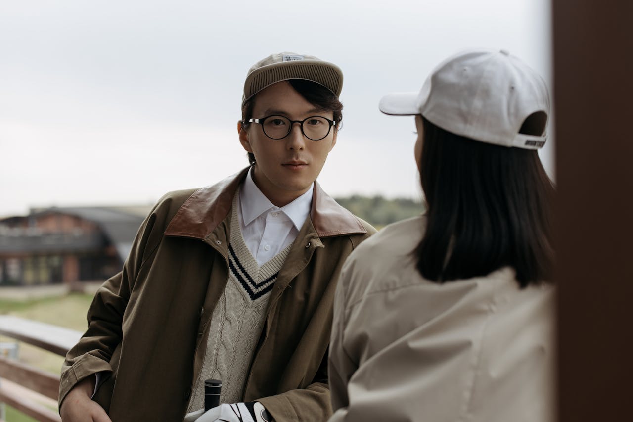 Fashionable couple in casual attire enjoying a moment on an outdoor balcony.